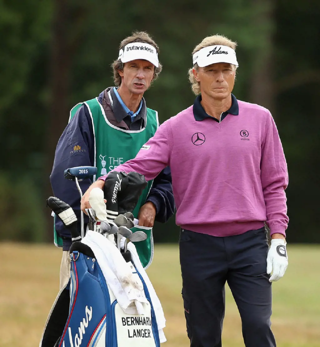 Bernhard Langer of Germany stands with his caddie Terry Holt on the second hole during the first round of The Senior Open Championship at Sunningdale Golf Club on July 23, 2015 in Sunningdale, England.