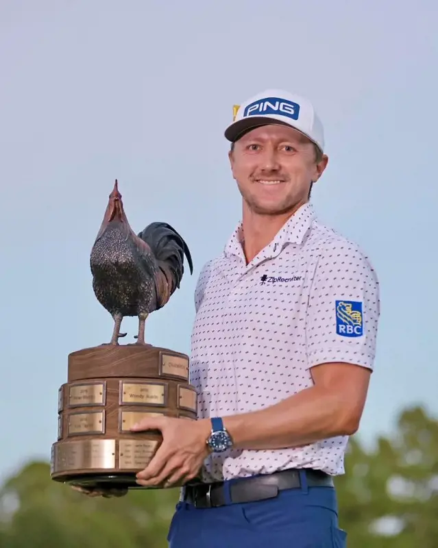 Mackenzie Hughes holds his trophy high after his PGA Victory at Sanderson Farms Championship
