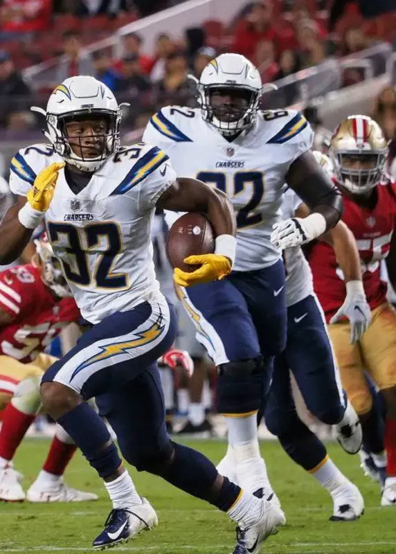 Chargers's  Alohi Gilman run with the ball in his hands from the players of 49ers.