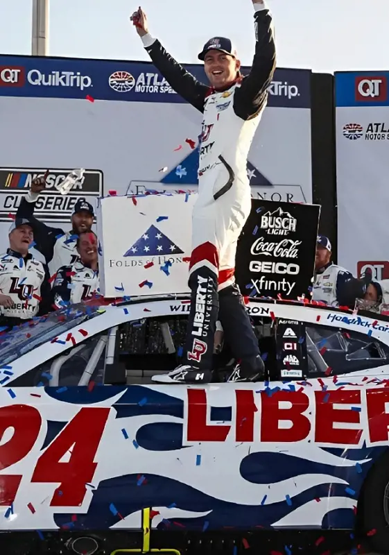 William Byron celebrates his Atlanta victory by climbing on the side of his car.