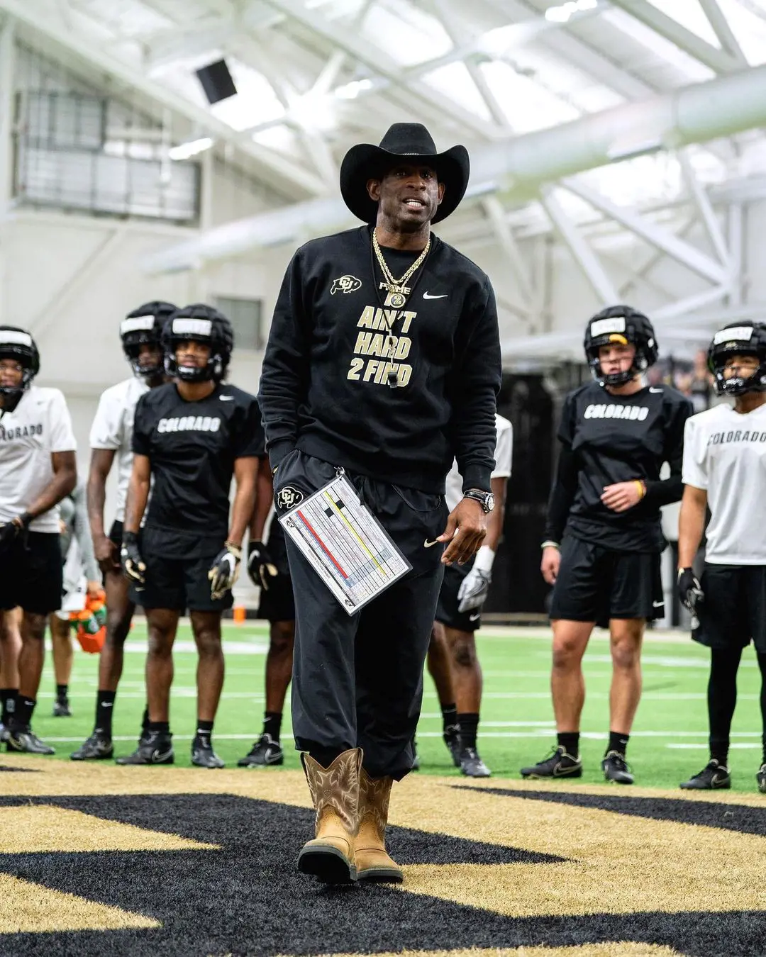 Sanders (Center in a hat) alongside Colorado football team mentoring them. He is one of the highest paid head coach in NCAA division one football